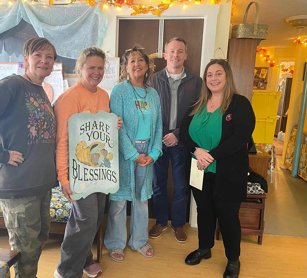 5 people standing with a sign that says share your blessings