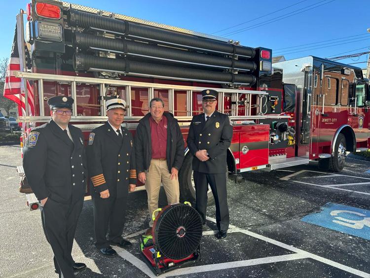 Pictured are members of the Jewett City Fire Department and Michael Alberts standing in front of a fire truck.