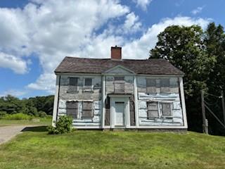 Pictured is a house sitting in a field.