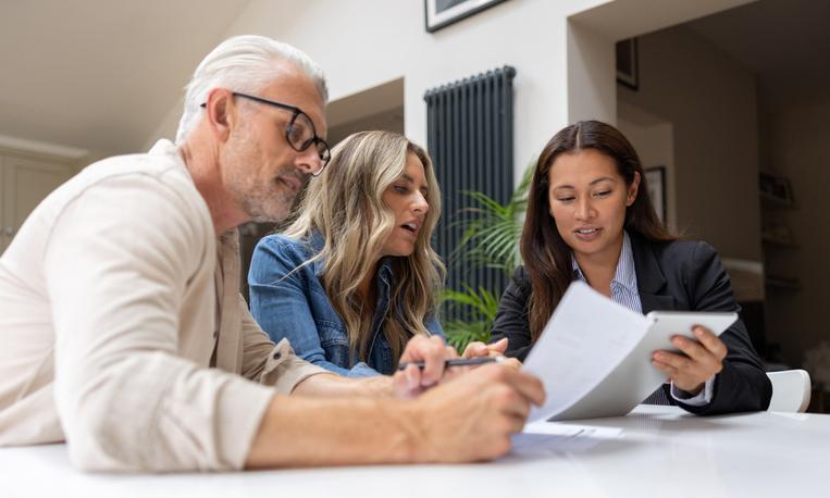 House-buying couple speaking with a financial advisor