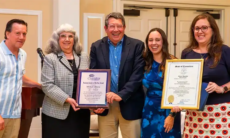 Group photo of 5 people holding up two awards.