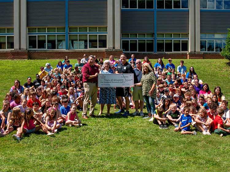 Group photo with people presenting a big check.